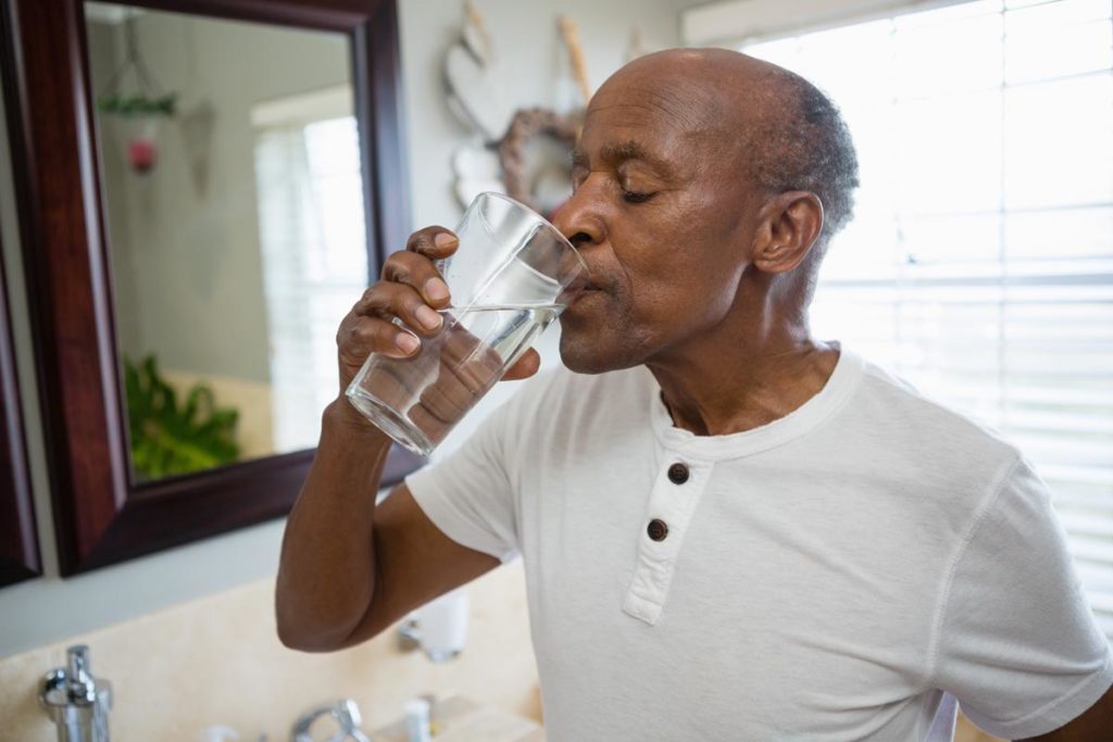Man drinking water to exemplify how to maintain hydration for seniors