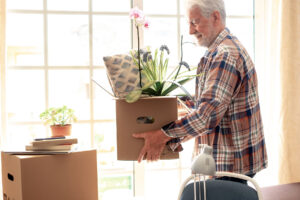 senior man holding box with orchid in it while enjoying scenting for assisted living
