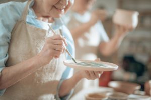 Woman painting, showing one of many hobbies for seniors