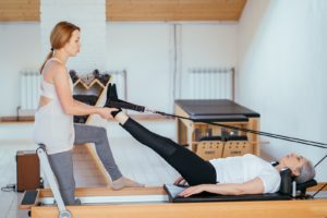 bigstock-Instructor-Performing-Pilates-353774081-1