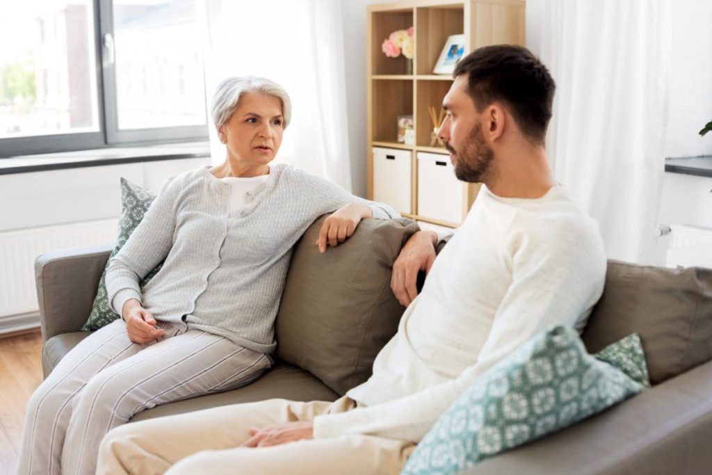woman and son sitting on couch discussing reasons for independent living