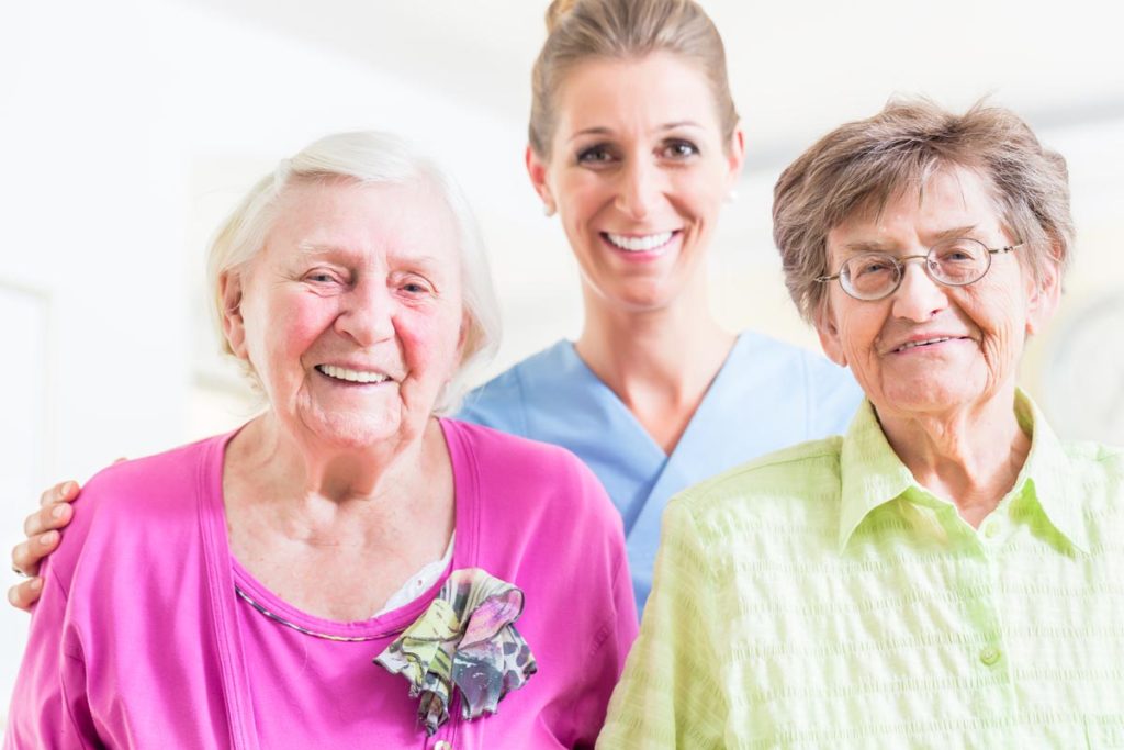 Two older adults with a member of a senior living staff