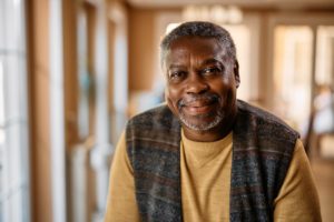 Man indoors smiling and experiencing the benefits of long-term senior care