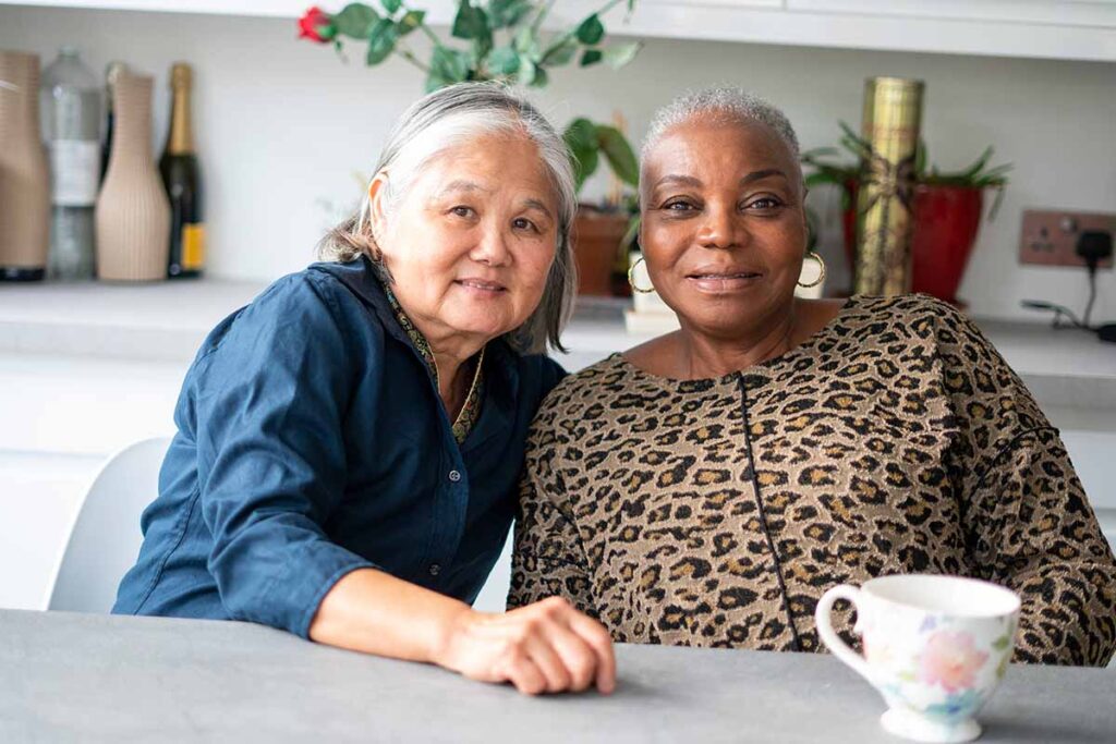 Two older women enjoying tea together and building friendships in retirement