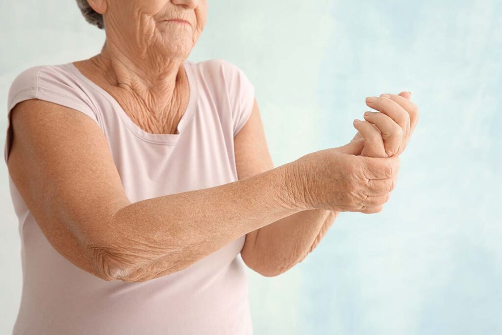 Older woman grasping her injured wrist and dealing with chronic pain in older adults