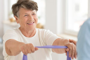 Senior woman participating in physical therapy as part of rehabilitation services