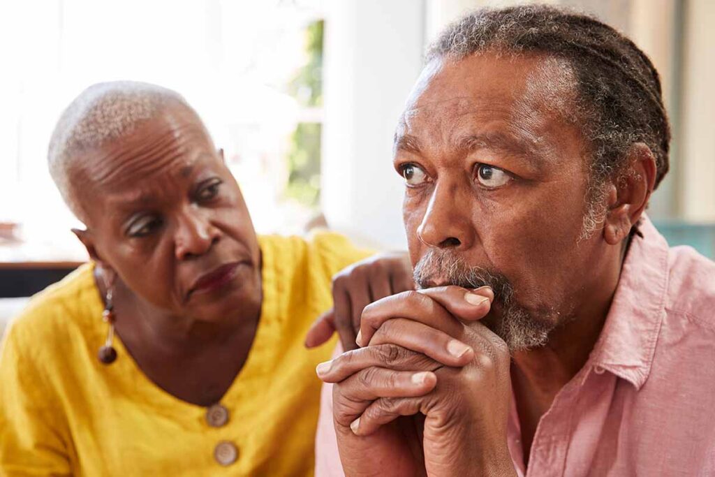 Concerned woman with elderly father discussing answers to the question what is alzheimers