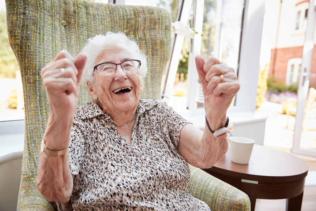 Happy women smiling while sitting in a comfortable chair and enjoying the benefits of senior independent living