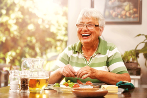 Woman smiling while enjoying a health lunch in an independent living community