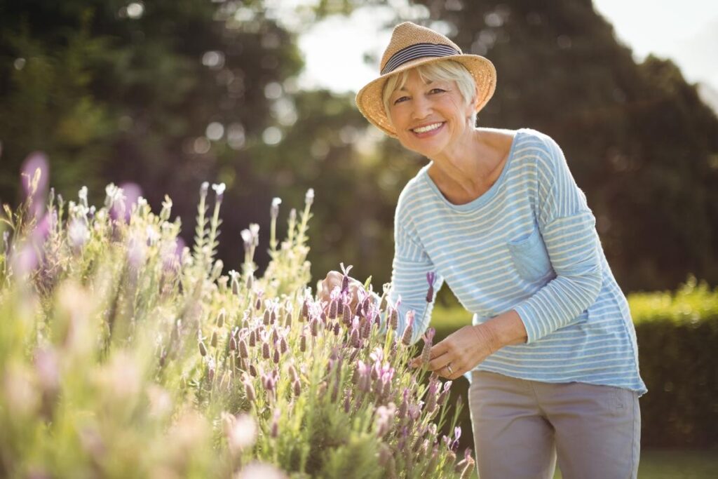 Senior woman smiling and gardening in memory care for Alzheimer's in Dallas Fort Worth