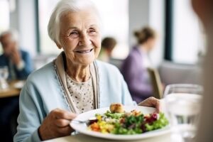 Happy older woman smiling while enjoying salad and other healthy foods for seniors
