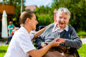 Happy person smiling while spending time outdoors with a caretaker in long term care for seniors in Dallas-Fort Worth