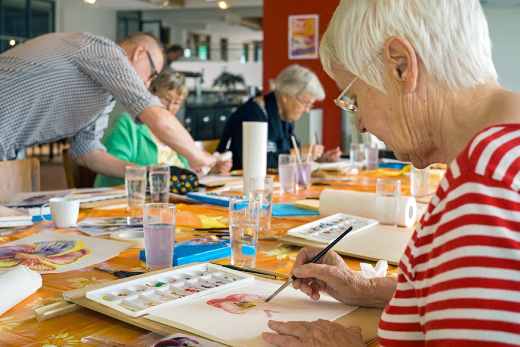 Group of seniors painting while enjoying self care activities for seniors