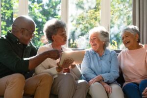 Group of older adults enjoying social time together in comfortable commons area after finding senior apartments in dallas tx