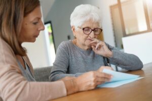 Younger person helping older adult choose from a list of mental health activities for seniors
