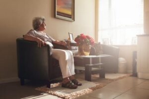 Senior sitting on comfortable couch in beautifully decorated room enjoying the view from their senior high-rise apartment