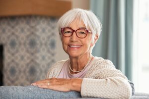 older adult sitting comfortably and smiling while in short term rehab for healing