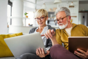 older couple searching the internet on laptop after getting advice about choosing the right senior living