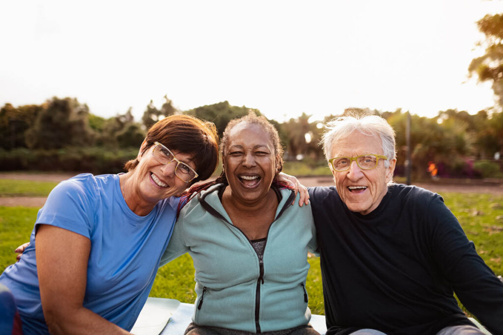 seniors and caretakers smiling for a photo while enjoying senior living amenities