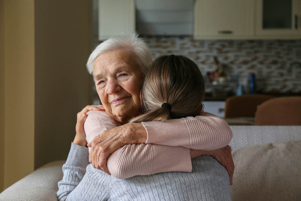smiling senior hugging daughter after learning signs you need long term skilled nursing care