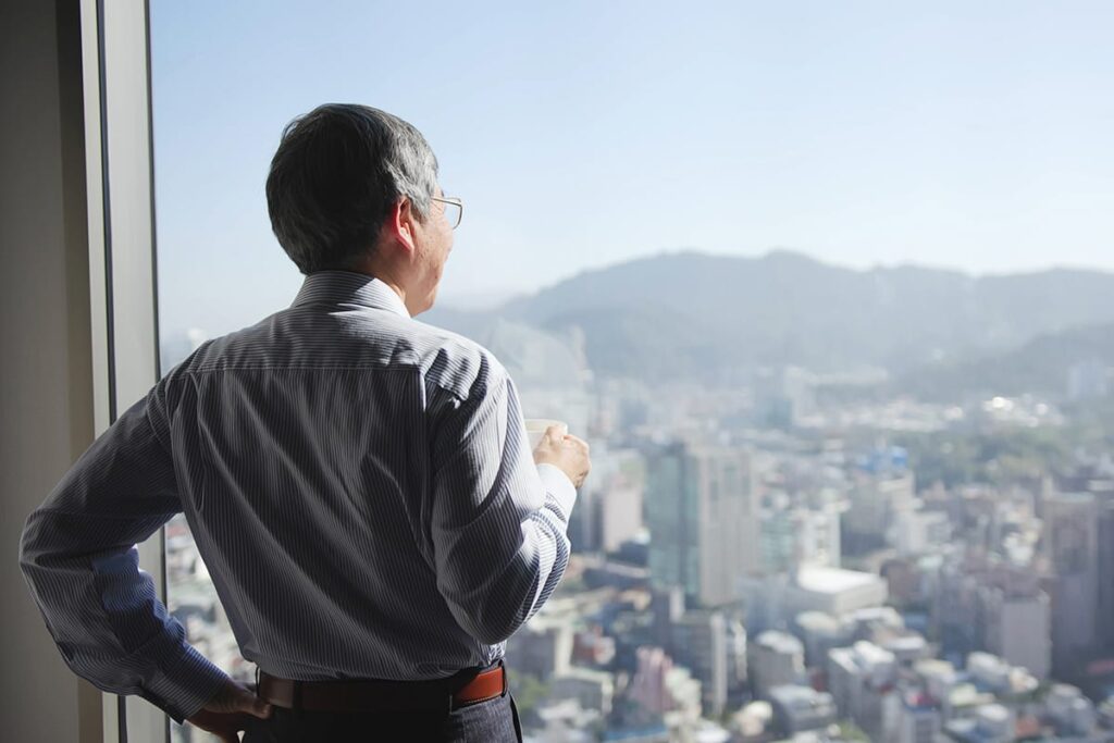 Man enjoying gorgeous view of the city after learning what is a senior high rise apartment