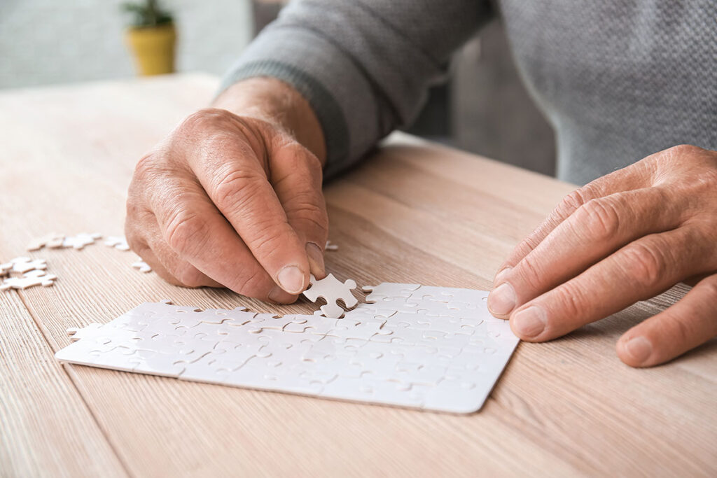 senior completing puzzle after finding answers to the question is memory loss genetic